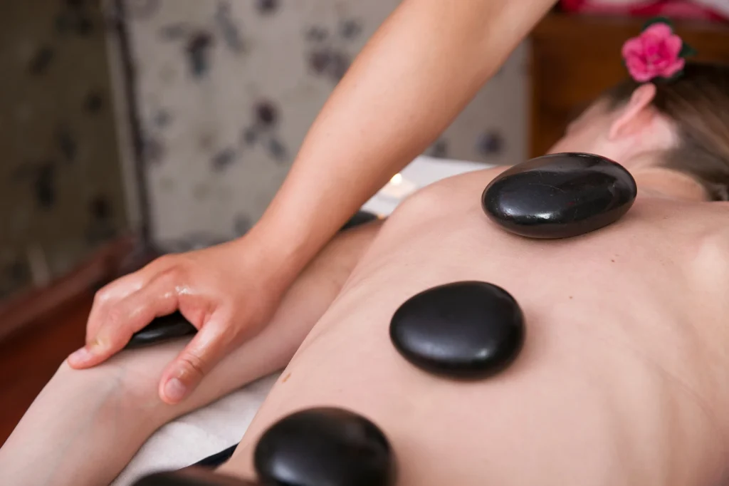 Spa treatment on woman using hot stones.
